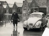 406503 Afbeelding van de Utrechtse persfotograaf L.H. Hofland met zijn auto (Volkswagen Kever) met bordje N.U.D. ...